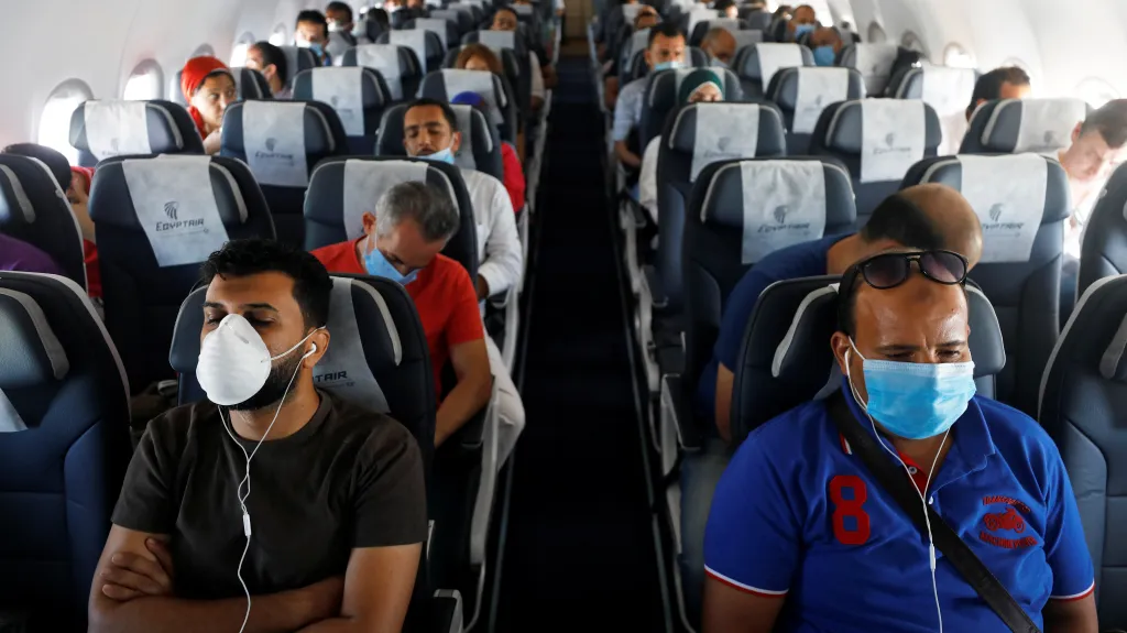 Cestující v letadle v průběhu koronavirové pandemie