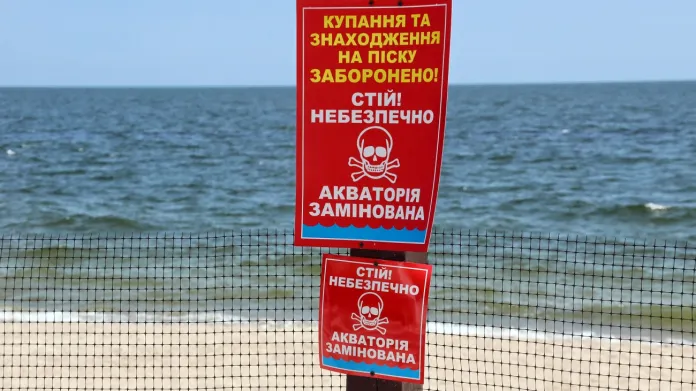 Nápis varující před nebezpečím min na pláži v Oděse