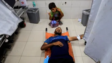 Palestinský chlapec pozoruje v nemocnici Nasser v Chán Júnisu svého otce, který byl zraněn při izraelském útoku