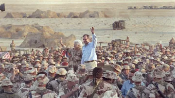 George Bush starší a jeho žena Barbara zdraví americké vojáky při Dnu díkuvzdání v Saúdské Arábii. Snímek je z roku 1990