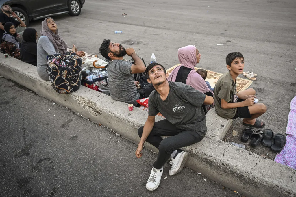 Dronové útoky v Bejrútu (Drone Attacks in Beirut) – Lidé úzkostlivě vzhlížejí během útoku izraelských bezpilotních letounů, když se shromažďují před budovami v bejrútské čtvrti Dahiyeh v Libanonu
