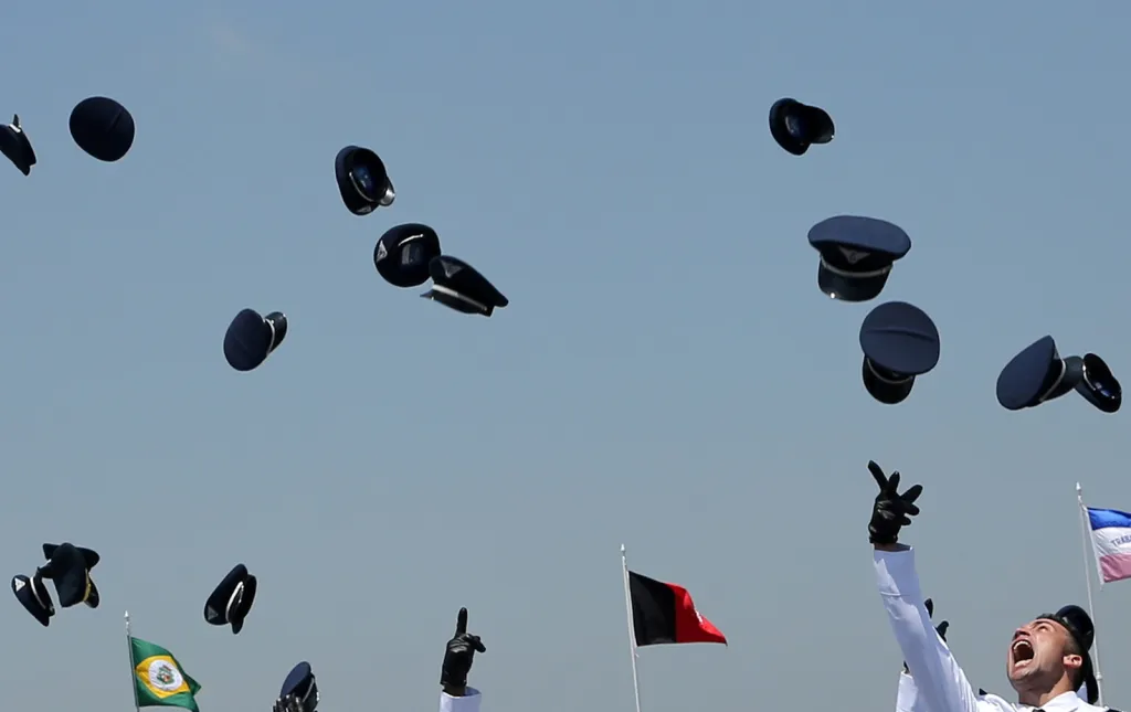 Čerství důstojníci leteckých sil vyhazují své čepice do vzduchu při oslavě dokončení studia na brazilské letecké akademii (AFA) ve městě Pirassununga