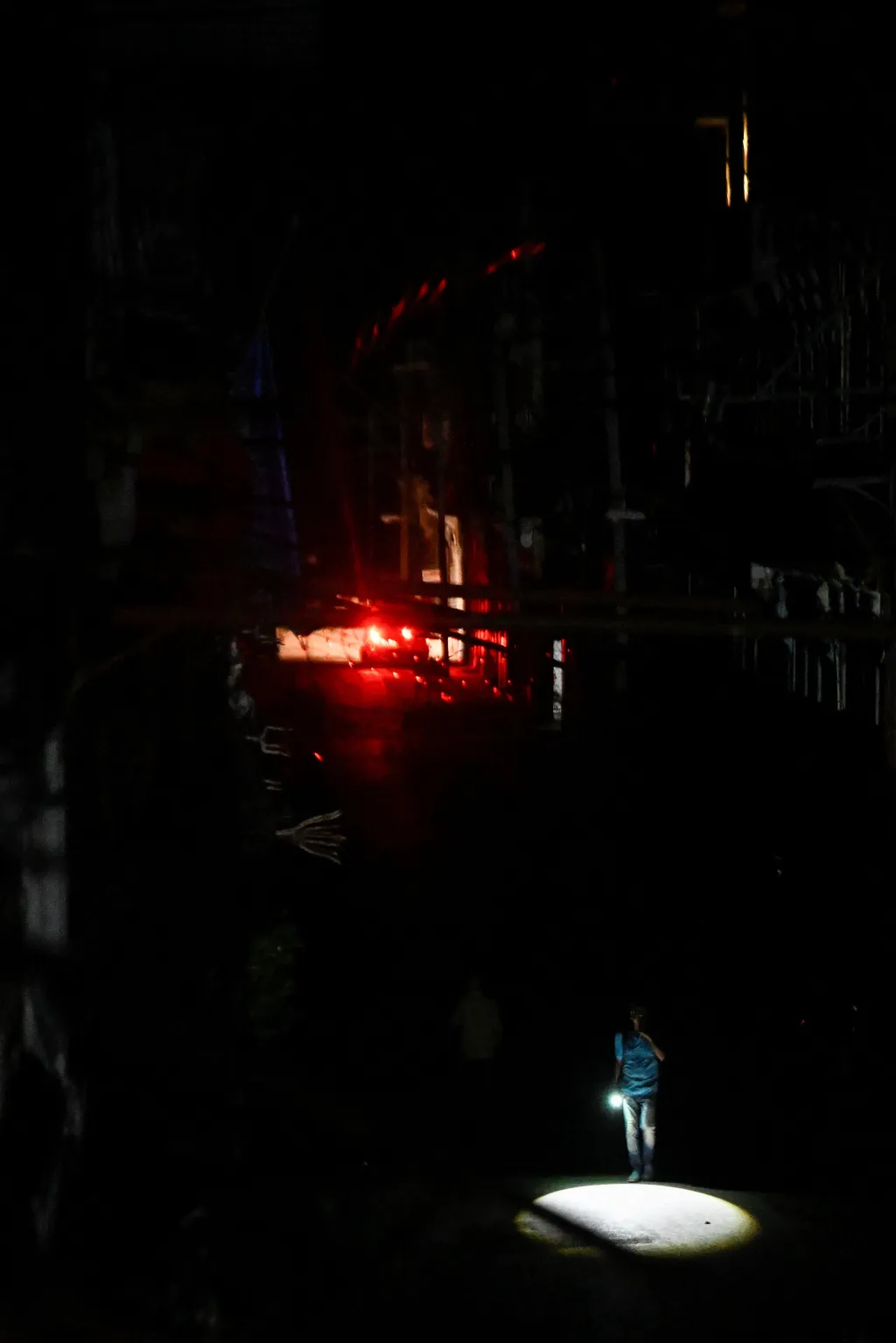 Muž si svítí na cestu ulicemi Havany