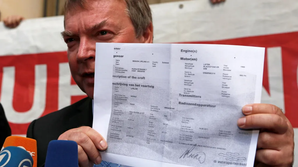 Kapitán Claus-Peter Reisch drží certifikát o registraci lodi Lifeline