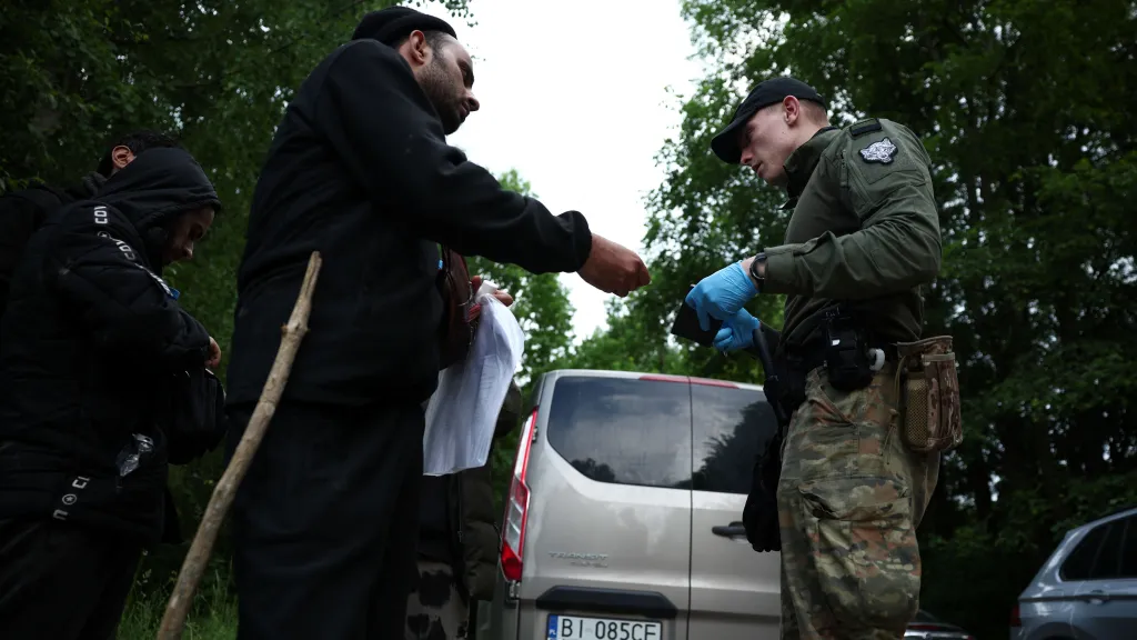 Ilustrační foto - migrant ukazuje doklady polskému pohraničníkovi (červen 2024)