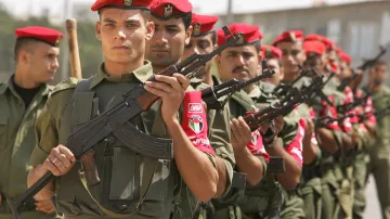 Příslušníci palestinských bezpečnostních sil drží zbraně na ulici poblíž židovské osady Morag na jihu Pásma Gazy. V příštích dnech se rozmístí v sousedství izraelských osad, aby se připravili na převzetí odpovědnosti v těchto oblastech, až izraelští vojáci a osadníci odejdou. Foceno 12. srpna 2005