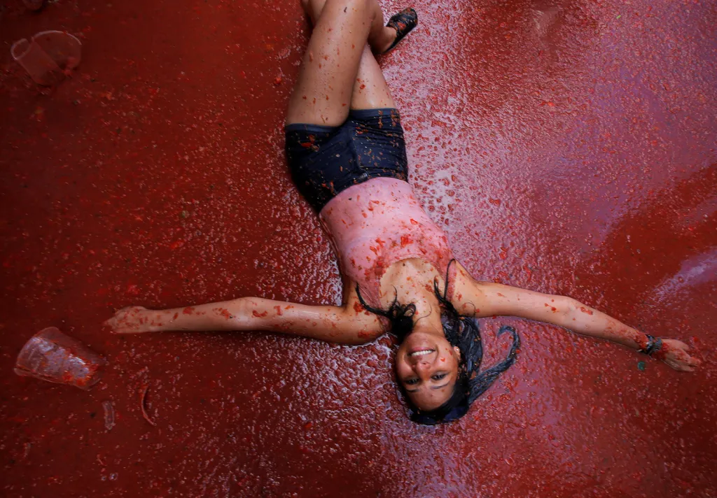 Účastnice španělského festivalu Tomatina v rajčatové kaši v ulicích vesnice Bunol nedaleko Valencie