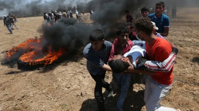 Palestinci odnášejí raněného demonstranta,  Autor: Ibraheem Abu Mustafa,  Zdroj: Reuters