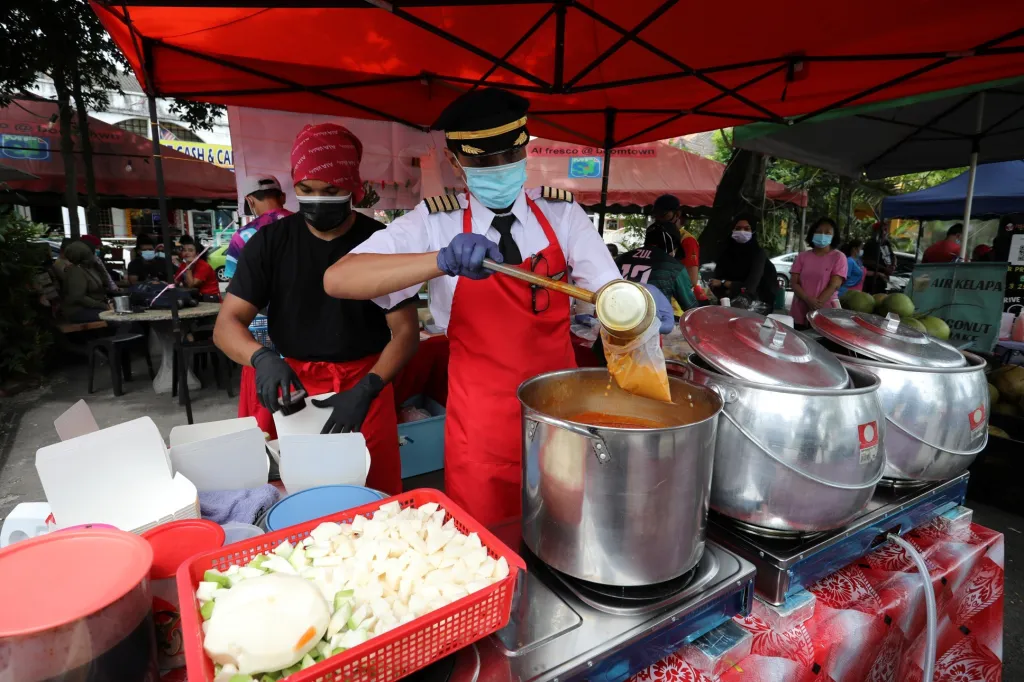 Malajský pilot Azrin Mohamad Zawawi připravuje jídlo ve svém stánku v Subang Jaya v Malajsii. Důvodem změny profese byla láska k jídlu a propuštění několika stovek zaměstnanců aerolinek, kde Azrin pracoval