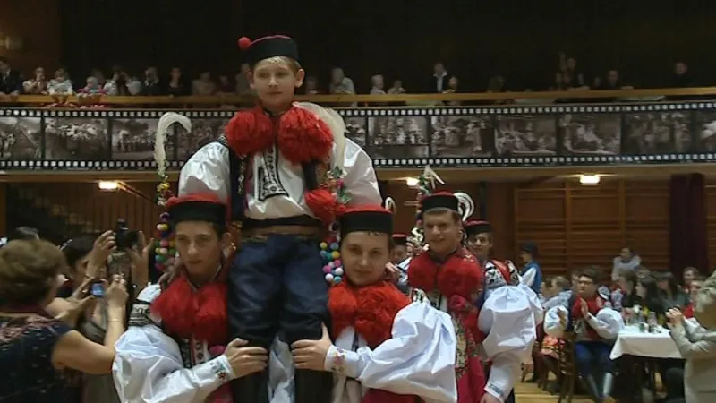 Starší chlapci nesou na ramenou budoucího krále