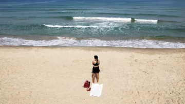 K dvěma minutám ticha se připojila i žena na pláži u Tel Avivu