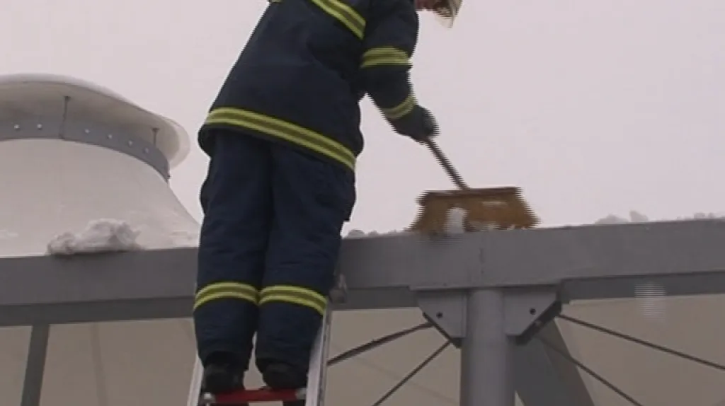 Hasiči odstraňují namrzlý sníh ze střech