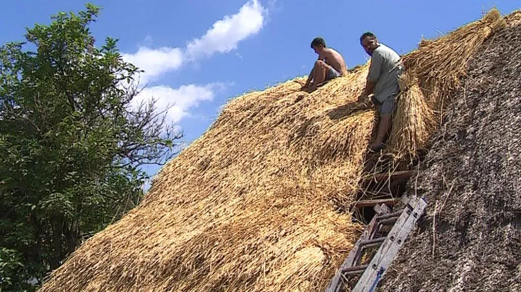 Doškář při práci na střeše