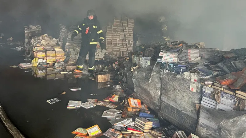 Hasič ve skladu firem Ranok a KnyhoLand v Charkově zničeném ruským útokem (1. srpna 2026) 