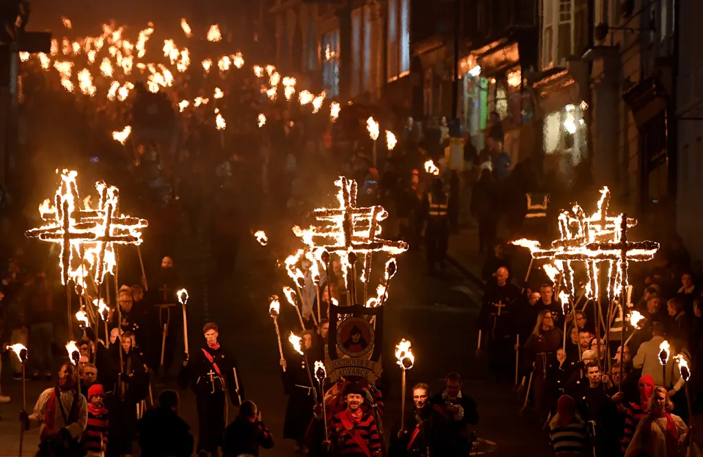 Účastníci průvodu městem během svátku Bonfire Night v britském městě Lewes.
