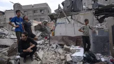 Palestinci prohlížejí trosky domu v Pásmu Gazy zničehého bombardováním