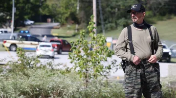 Policista střeží bránu před vybuchlou továrnou na výbušniny v Tennessee