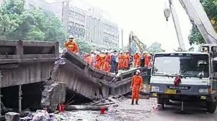 Čínští záchranáři odklízejí trosky zříceného mostu.