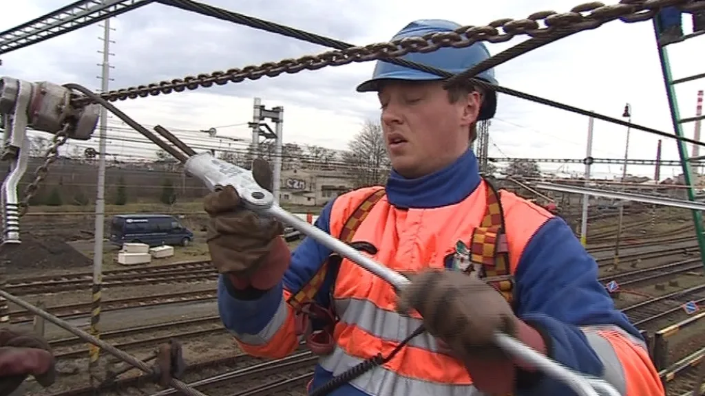 Dělník vyměňuje dráty trakčního vedení na břeclavském nádraží