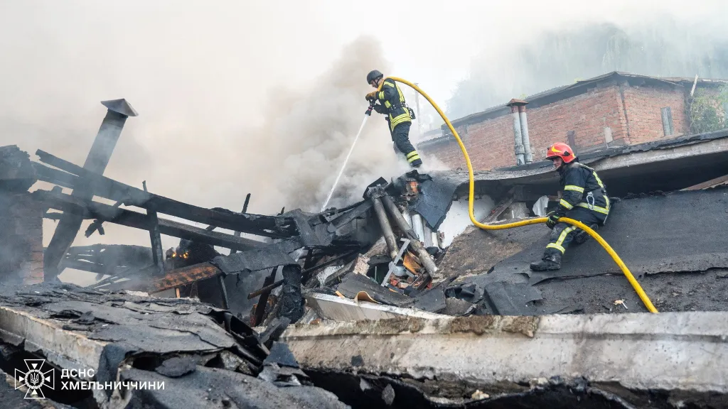 Hasiči pracují na místě zničených garáží automobilového podniku, který byl zasažen během ruského útoku drony a raketami na město Chmelnycké