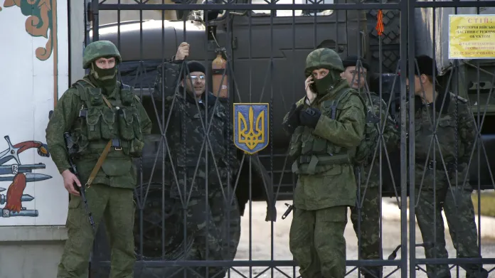 Neoznačení ruští vojáci před branou základny s ukrajinskými vojáky v Perevalne, 3. března 2014