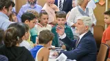Prezident Pavel rozdává při setkání s žáky autogramy