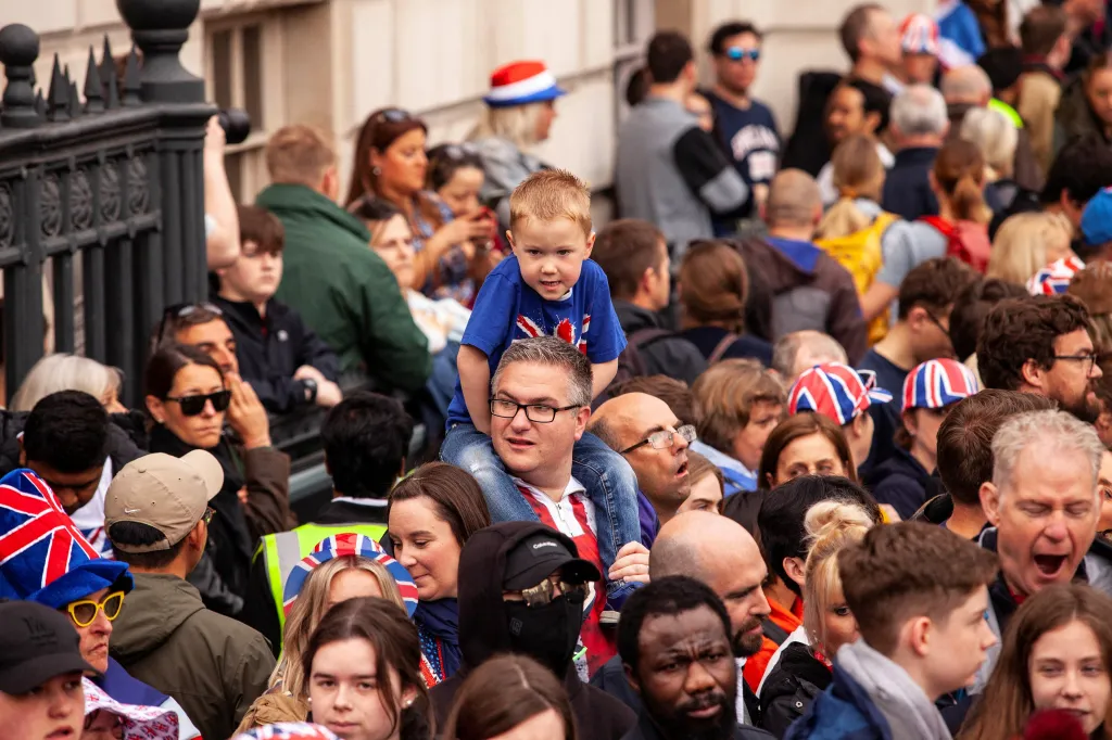 Přihlížející veřejnost v ulici Whitehall, kterou projížděl zlatý kočár s králem a královnou