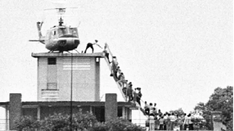 Důstojník CIA pomáhá evakuovaným po žebříku do vrtulníku na střese americké ambasády v Saigonu (29. dubna 1975)