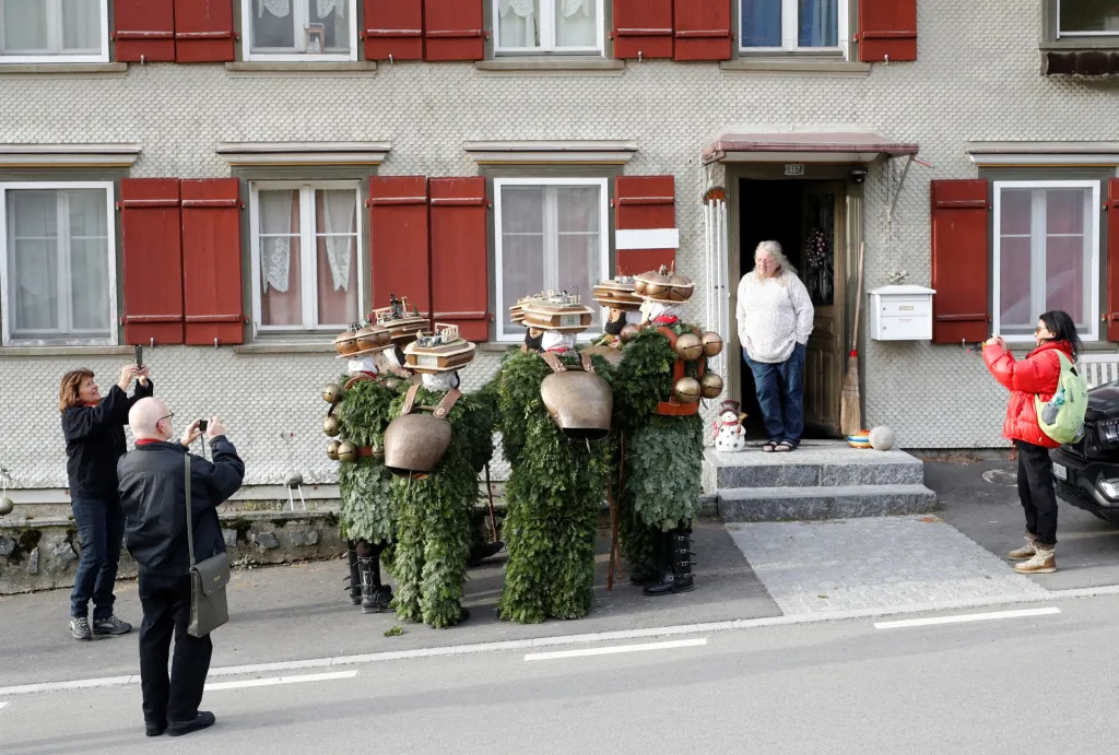 Muži oblečení v kostýmu postaviček "Chlaeuse"putují vesnicí Urnaesch ve Švýcarsku