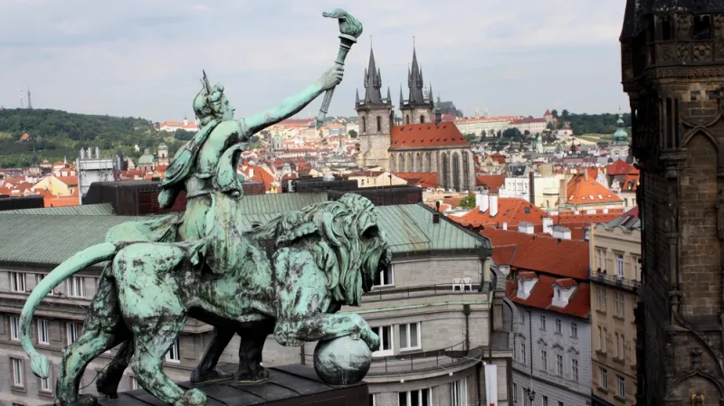 Postava kráčejícího genia v rozevlátém rouše na střeše ČNB