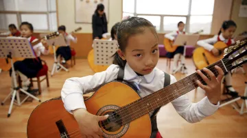 Dívky při hře na kytaru v dětském školícím centru Mangyongdae v centrální části Pchjongjangu