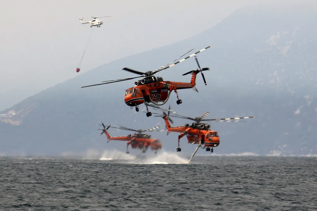 Během uplynulého týdne dělaly starosti hasičům lesní požáry v mnoha zemích. Požáry zasáhly lesy prakticky v celé jižní Evropě, v USA, Kanadě, ale vyskytly se i v Alžírsku a Tunisku. Na snímku zasahuje letka helikoptér v Řecku u ostrova Euboia