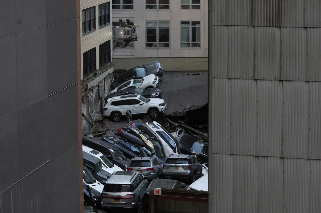 Po zhroucení patrového parkoviště zůstala auta v sutinách