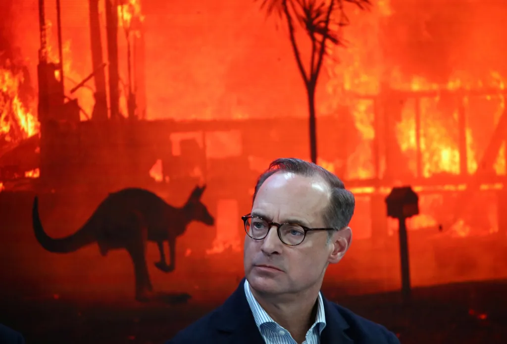 Na zasedání v Davosu se řešila i otázka dopadů životního prostředí na ekonomiku. Na snímku je Oliver Baete, šéf společnosti Allianz. Stojí před obrazovkou, která ukazuje snímek z požáry postižené Austrálie