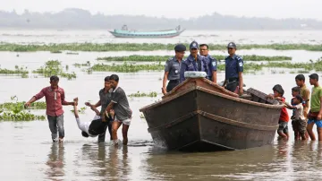 Záchranáři odnášejí oběť lodního neštěstí v Bangladéši