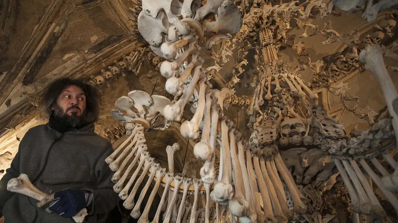 Restaurátor Tomáš Král osazuje ramena lustru kosterními pozůstatky.