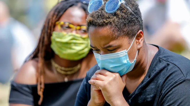 Lidé v Minneapolisu naslouchají projevu reverenda Sharptona během piety