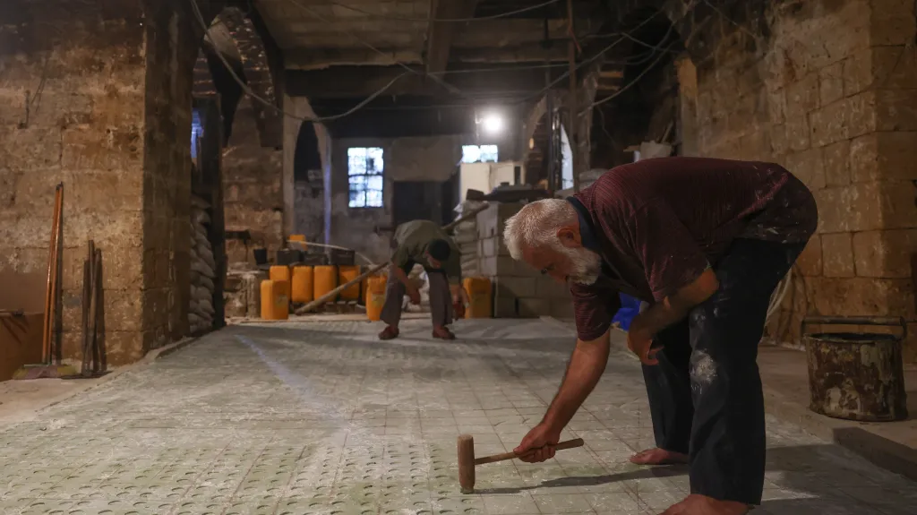 Pracovník mydlářské společnosti vytlačuje do mýdel logo