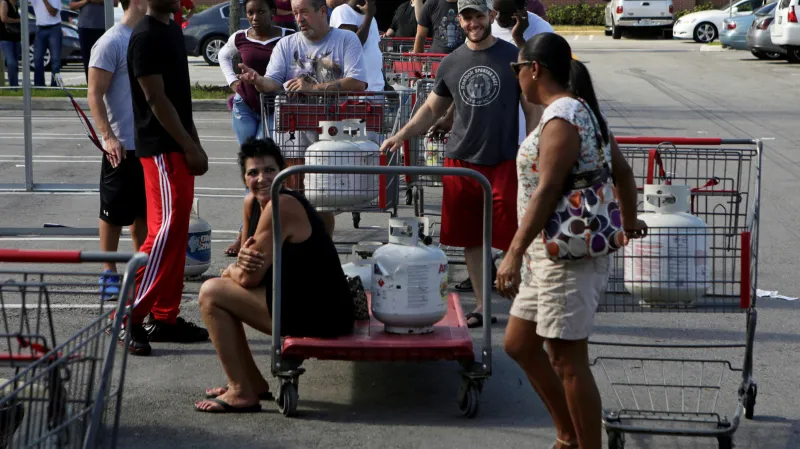 Lidé stojící ve frontě na doplnění propanbutanových lahví