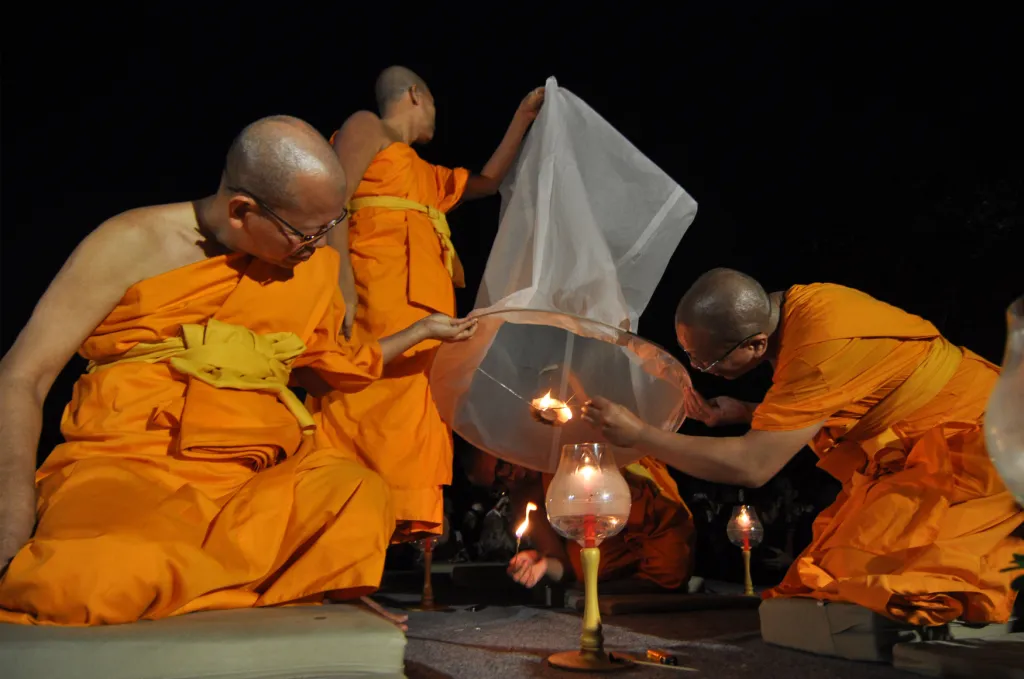 Buddhističtí mniši zapalují lampion štěstí