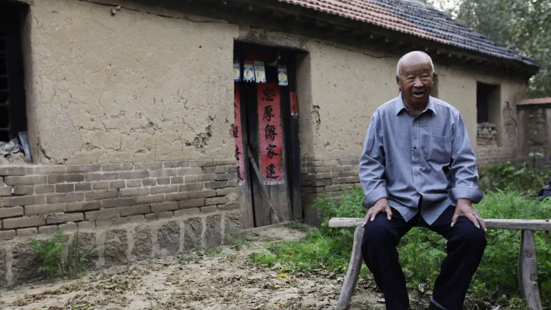 Otec Mo Jena před domem, kde nobelista vyrůstal