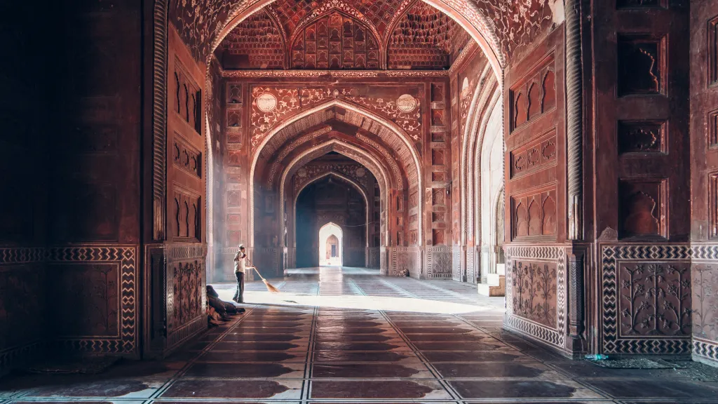 Rozbřesk (kategorie Cestování). Ranní světlo v komplexu mešity Tádž Mahal (Agra, Indie). „V jedné z nejnavštěvovanějších atrakcí Indie najdete na velkém území i ostrovy ticha a klidu. Snímek byl pořízen před úsvitem v západní části areálu. Líbil se mi rozdíl mezi velikostí architektury a okamžikem každodenní práce.“