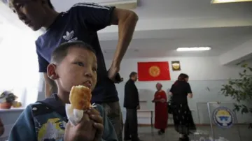 Kyrgyzský chlapec čeká, až rodiče vyjádří svůj hlas
