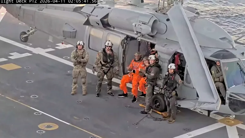 Astronauti Christina Koch a Victor Glover na palubě záchranné lodi po vyproštění z kapsle Artemis II