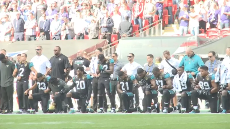 Hráči NFL klečící při hymně