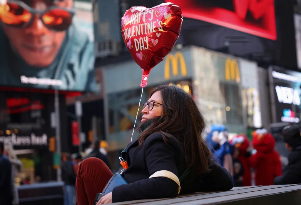 Žena sedí s tematickým balónkem na Times Square v New Yorku