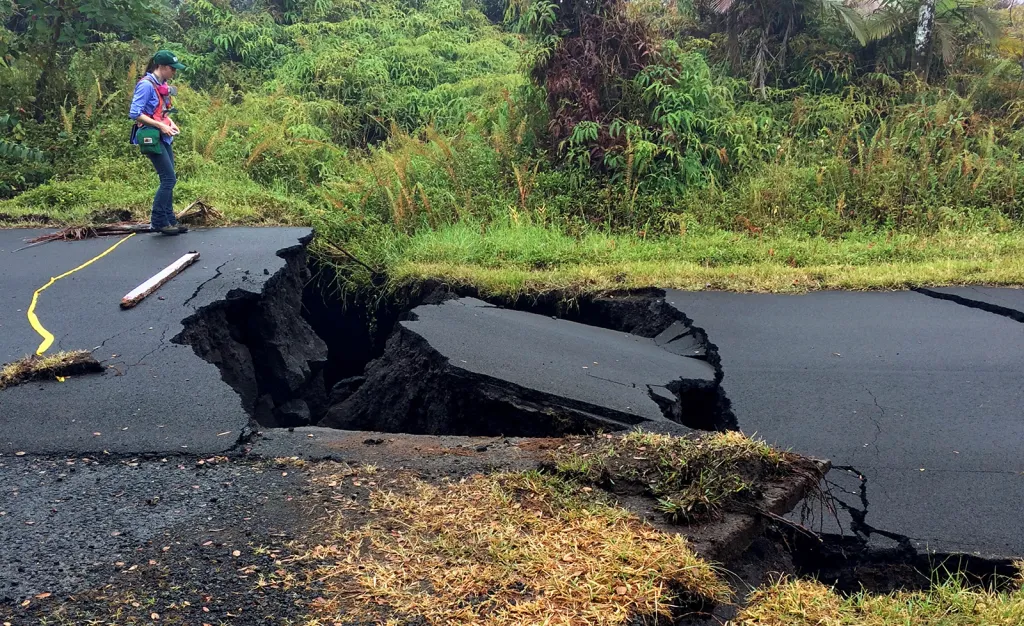 Geolog prošetřuje průrvu v silnici u Leilani, nedaleko aktivních erupcí vulkánu Kilauea na Havaji