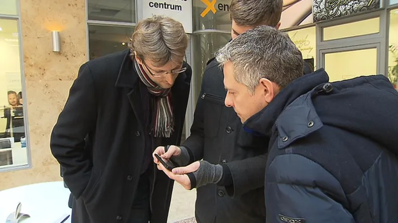 Redaktor ČT ukazuje zástupcům X Energie fotografii průkazu prodejce