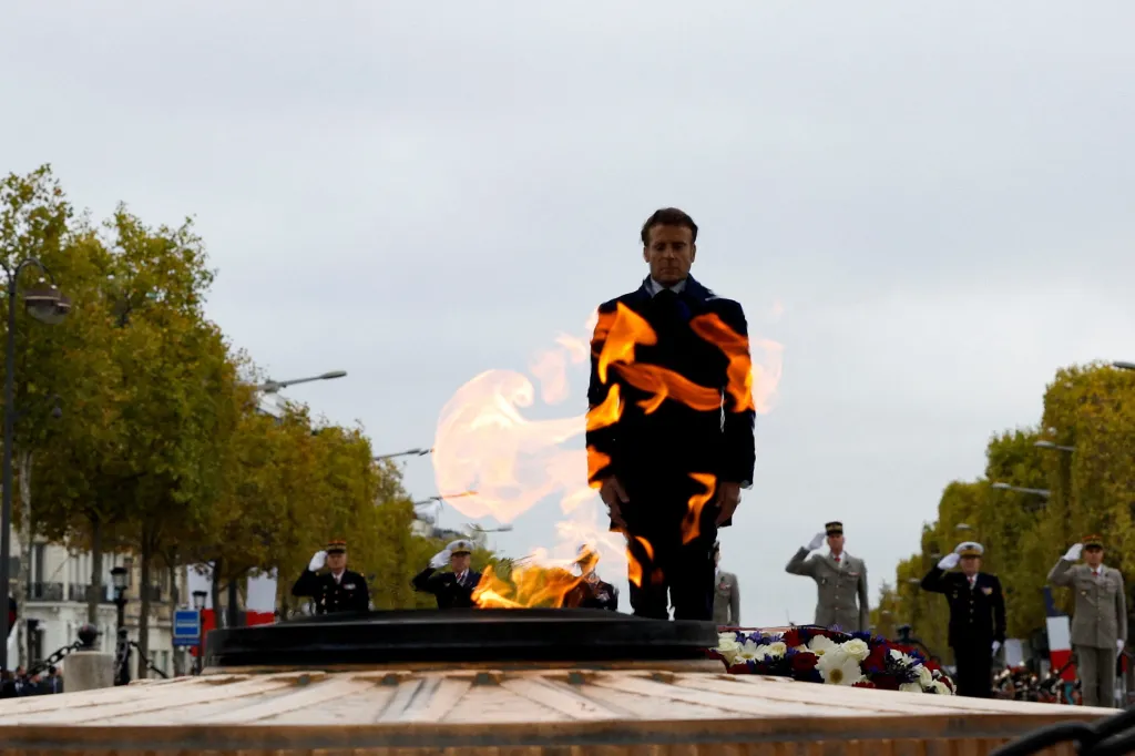 Francouzský prezident Emmanuel Macron stojí před hořícím plamenem hrobu Neznámého vojáka v Paříži.