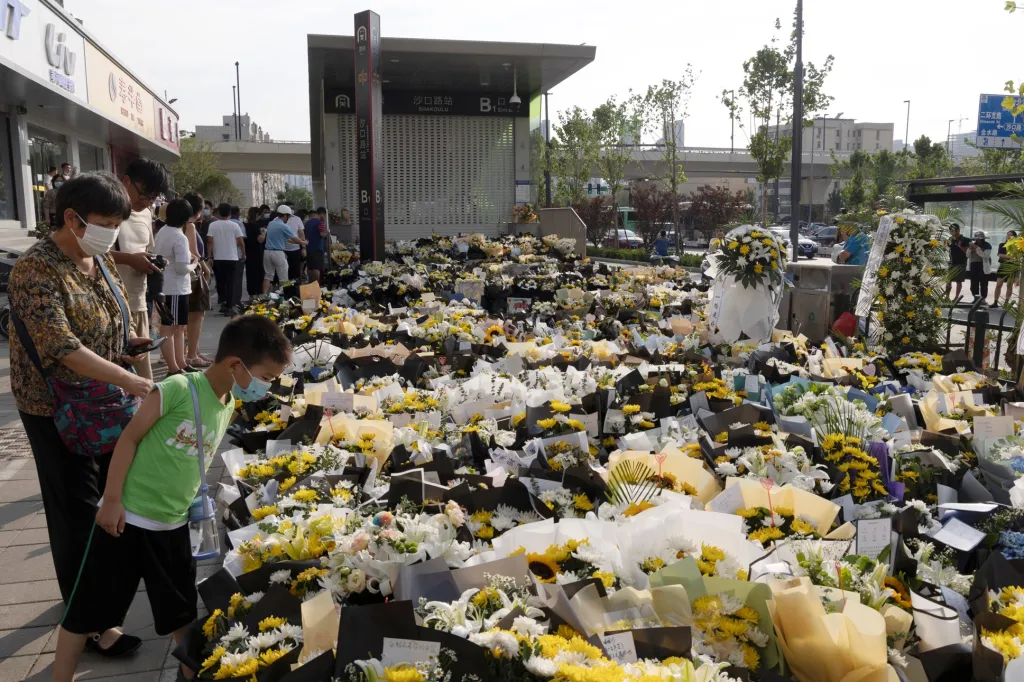 Lidé uctili památku obětí po povodních v čínském městě Čeng-čou. U jedné ze stanic metra linky 5, která byla zatopena, obyvatelé města přinesli stovky květin a pietně zaplnlili celé prostranství